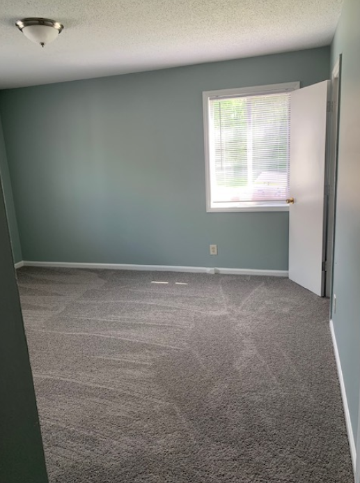 a room with a carpeted floor and a window