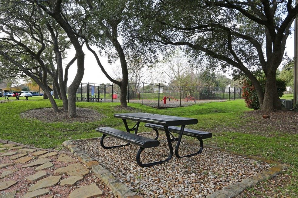 a picnic table in a park near a playground
