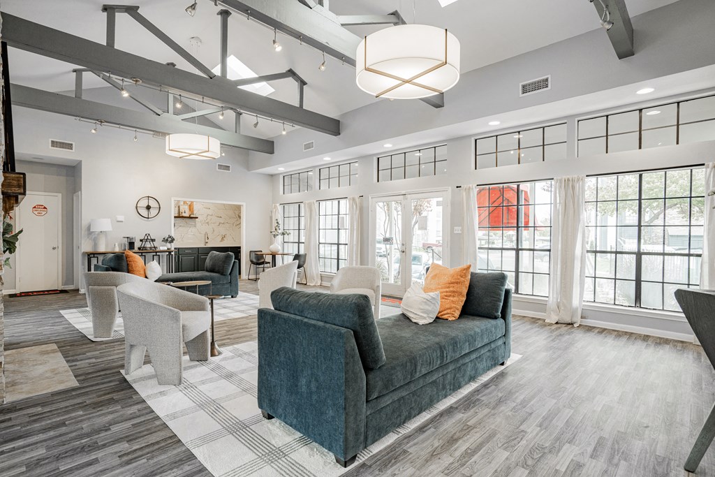 a large living room with couches and chairs and windows