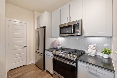 A kitchen with a stove top oven, microwave, and refrigerator.