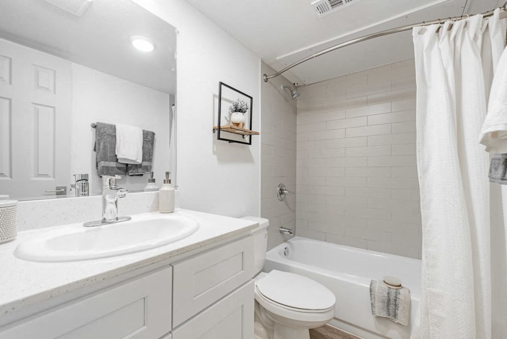 A white bathroom with a toilet, sink, and bathtub.