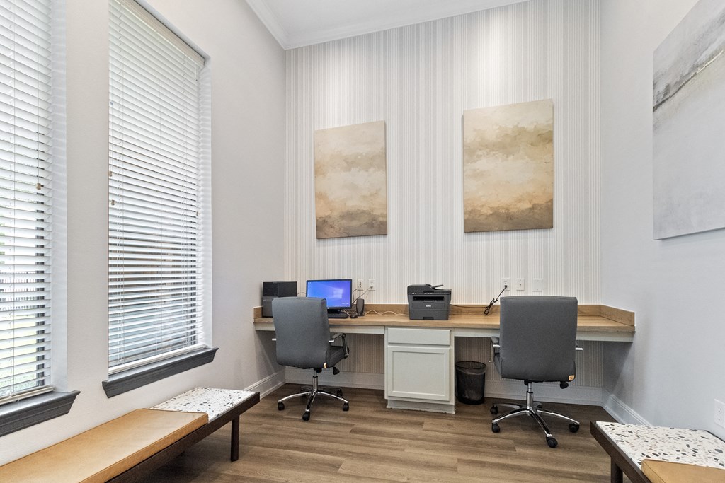 a home office with two desks and two chairs and a laptop