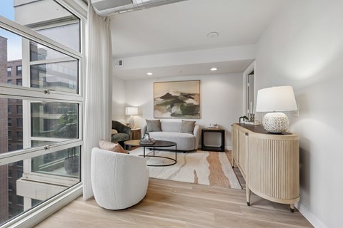 A living room with a white chair and a white lamp.
