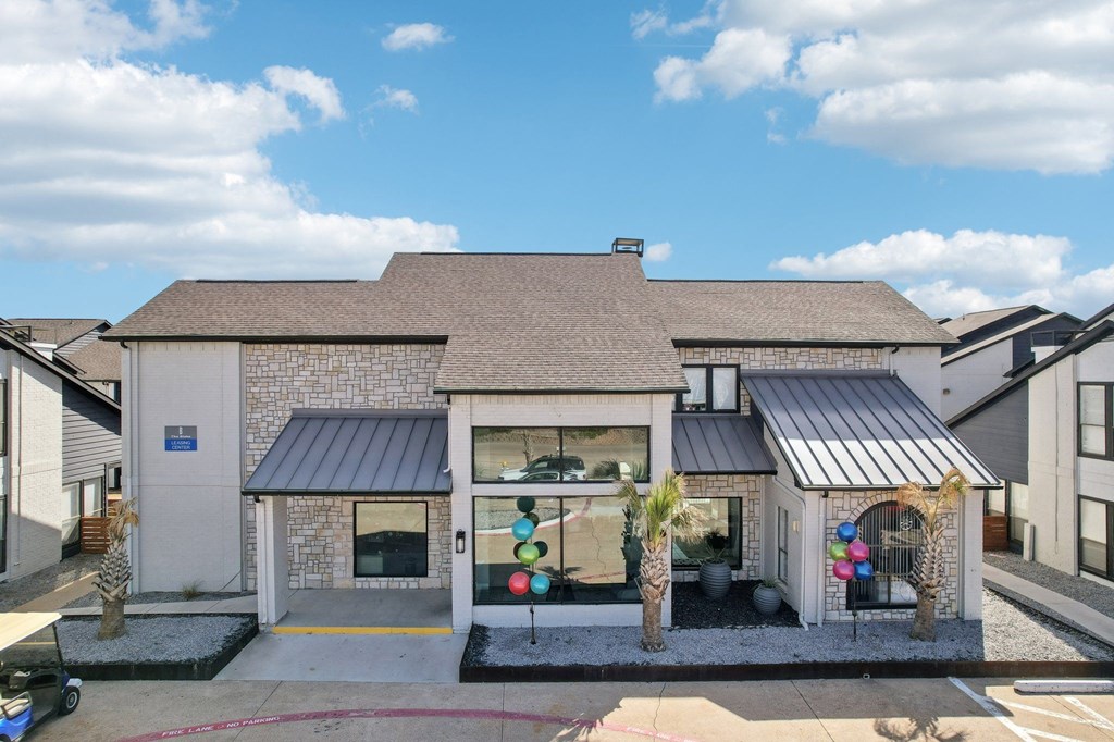 A house with a grey roof and a white wall with a black awning.