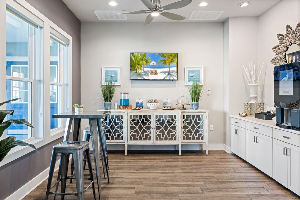 A modern kitchen with a bar area and a ceiling fan.