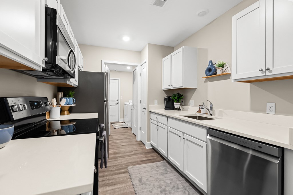 a spacious kitchen with white cabinets and stainless steel appliances