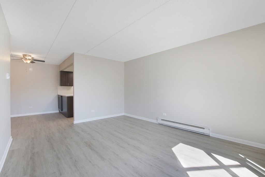 an empty living room with white walls and wood flooring