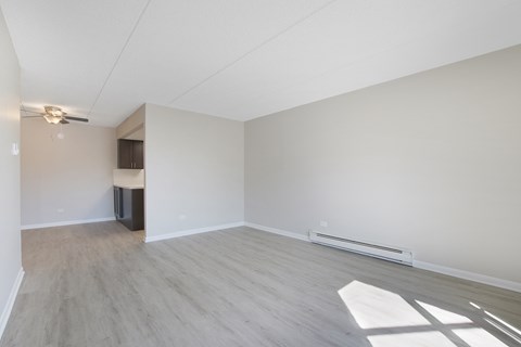 an empty living room with white walls and wood flooring