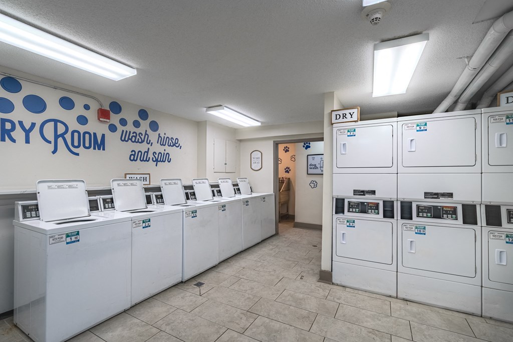 a row of washers and dryers in a laundromat with a row