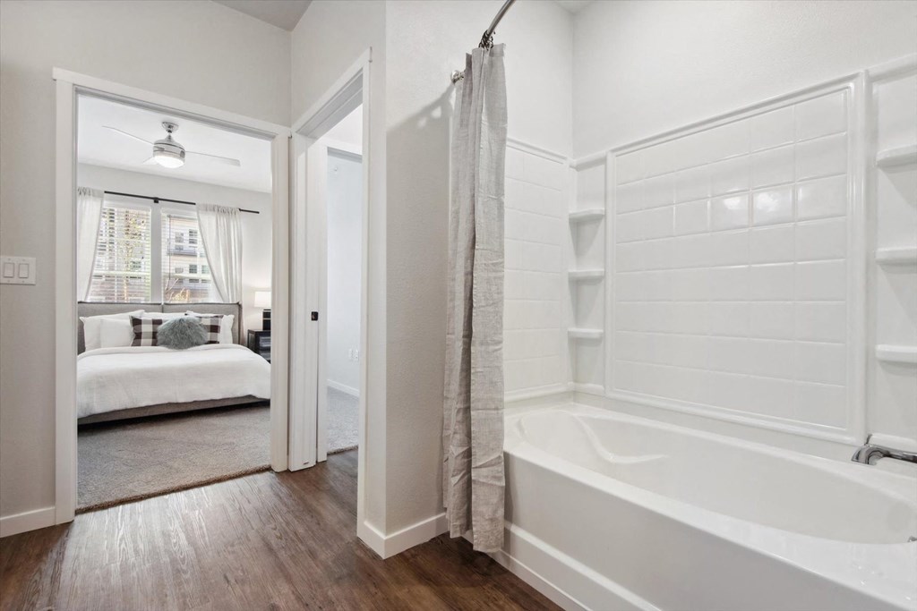 a bathroom with a tub and a door to a bedroom