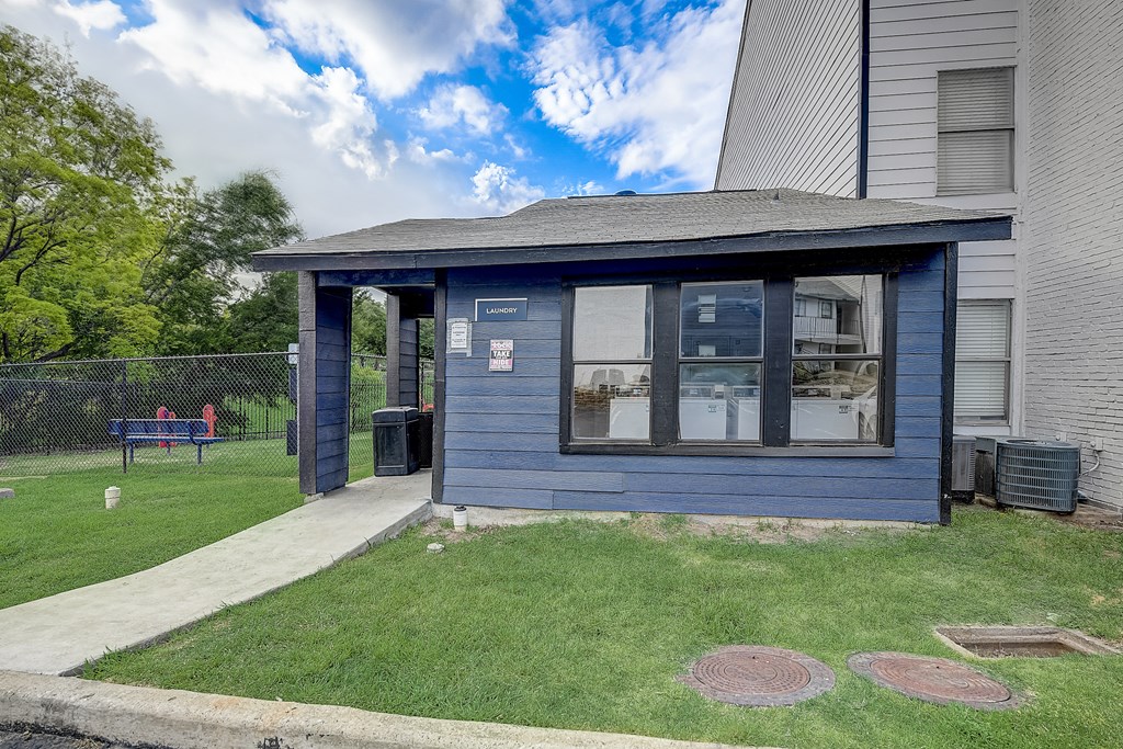 a small blue building with a bench in the background