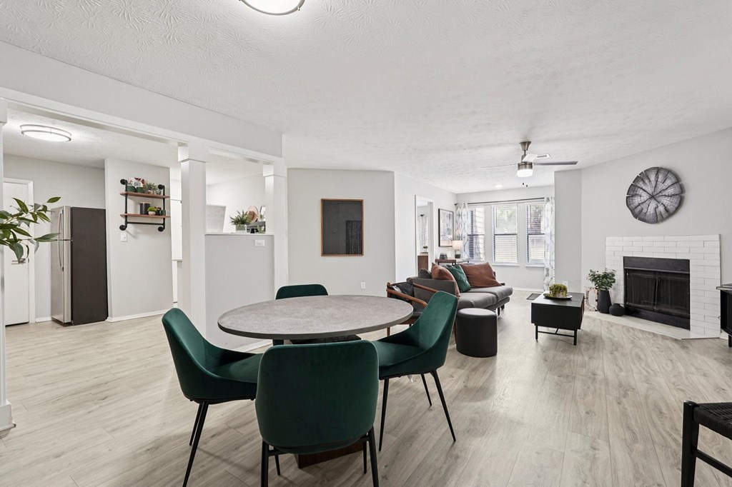 A modern living room with a fireplace and a dining table set up.