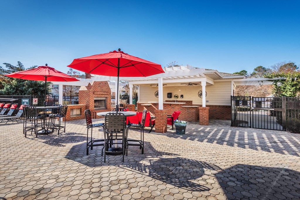 a patio with tables and chairs and umbrellas
