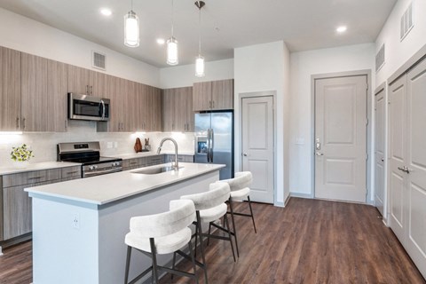 A kitchen with white chairs and a white counter.