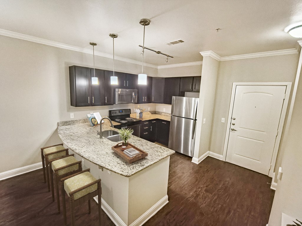 A kitchen with a granite countertop and stainless steel appliances.