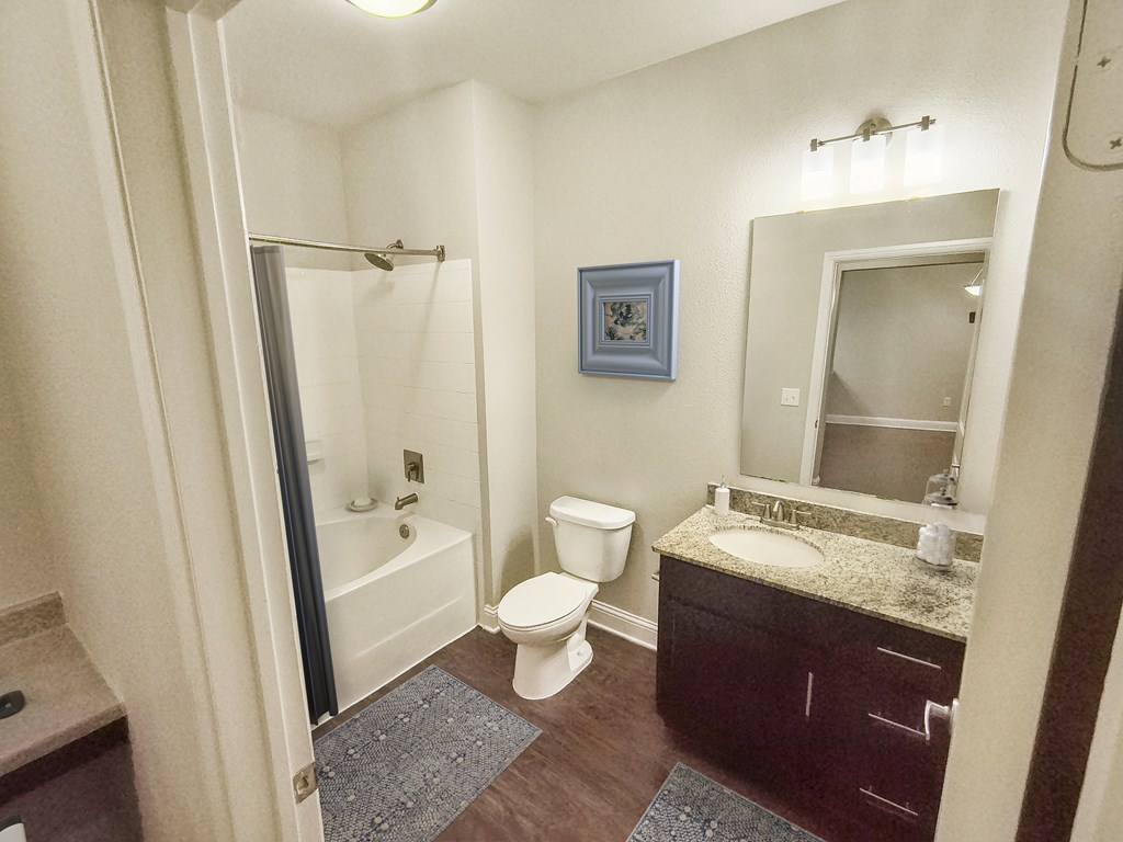 A bathroom with a toilet, sink, and shower.