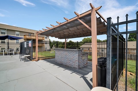 the clubhouse has a patio with a brick fireplace and a gazebo