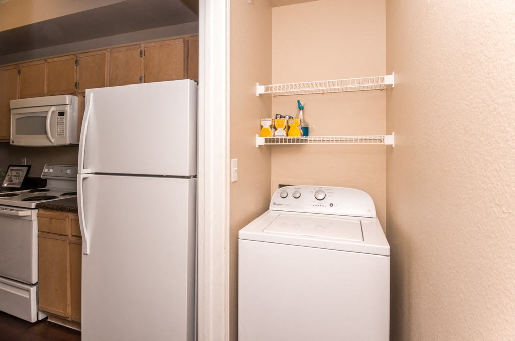 a small kitchen with a washer and dryer and a refrigerator