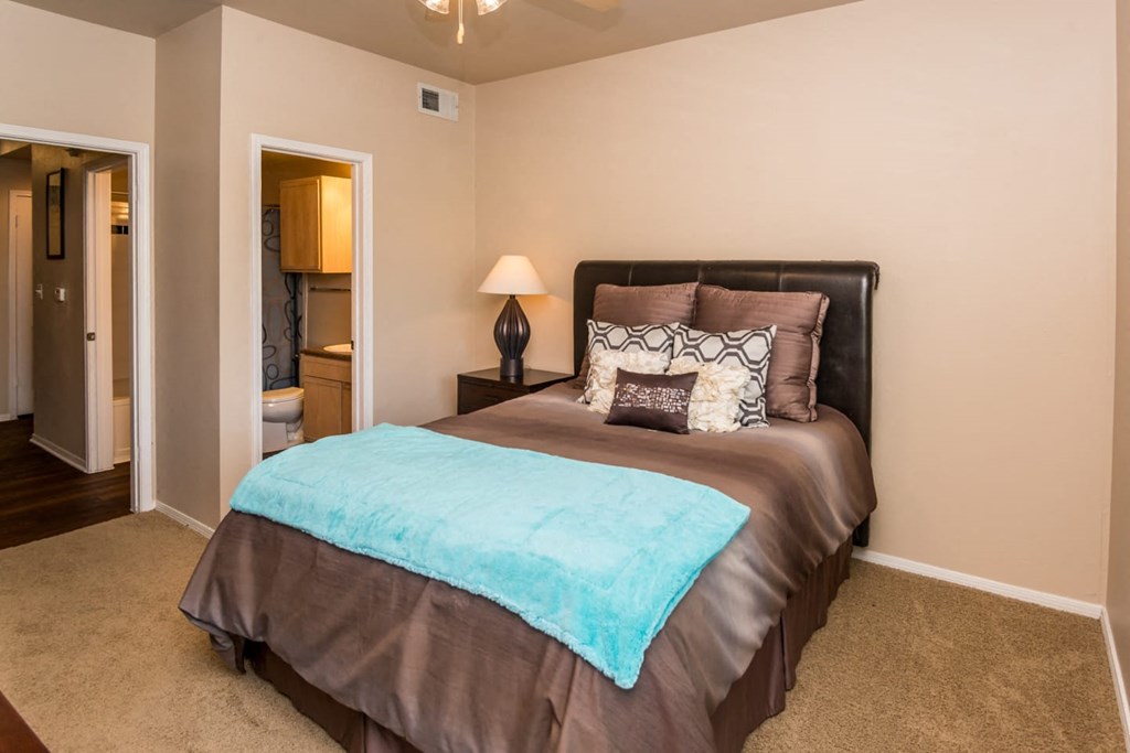 a bedroom with a bed and a door to a bathroom