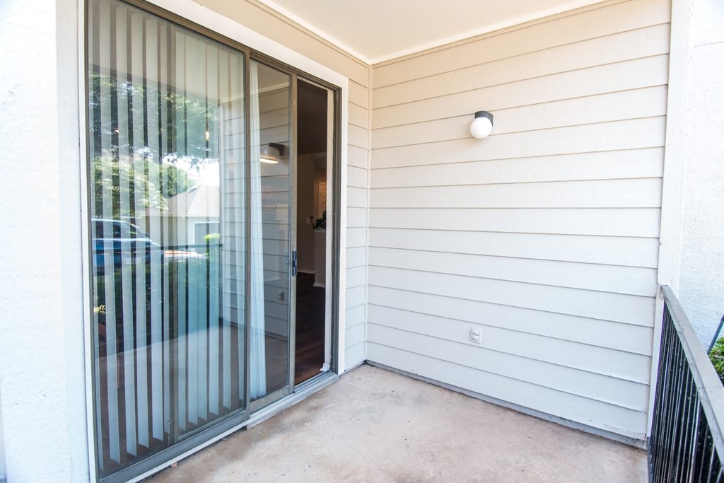 the entrance to a home with a glass door and a patio