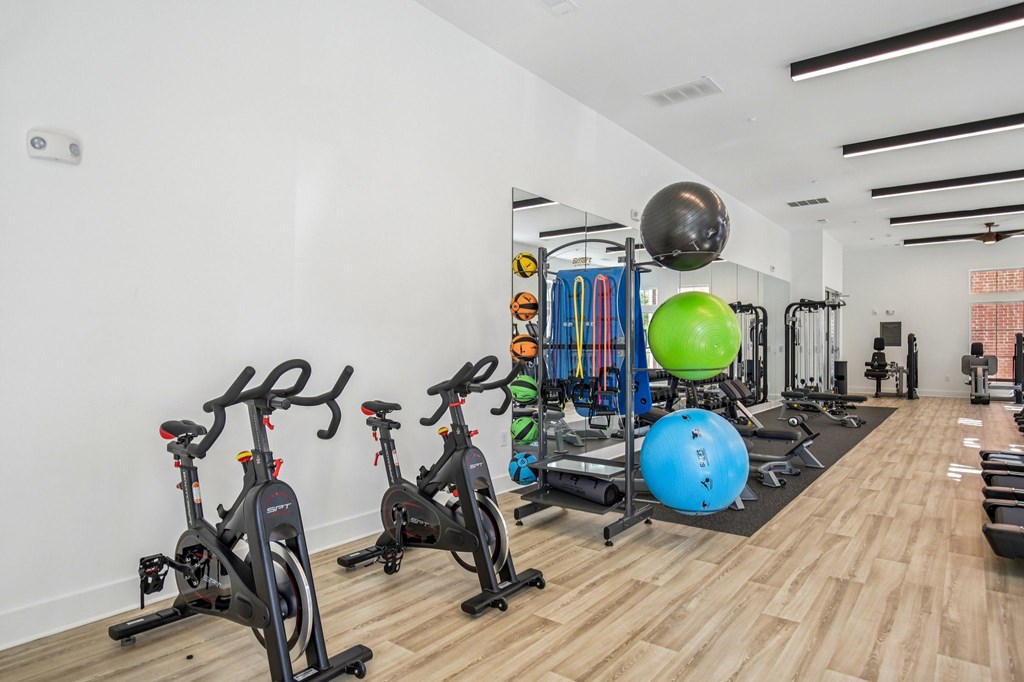 A gym with exercise equipment and a green exercise ball.