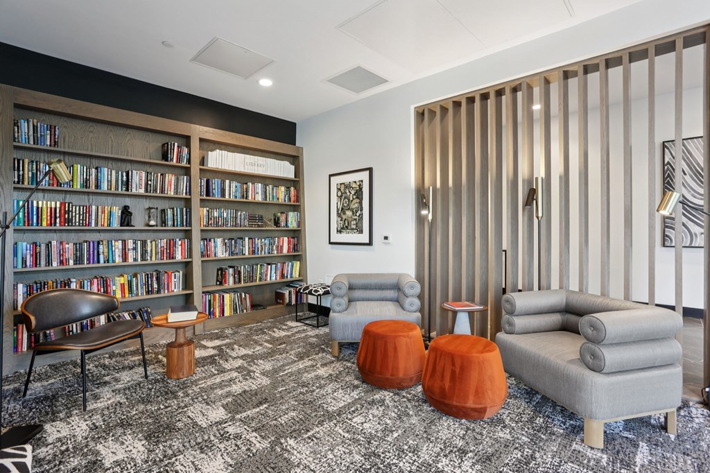 A living room with a bookshelf, a chair, a table, and a rug.