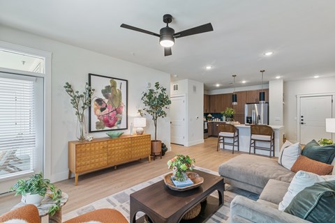 A living room with a brown sofa, a coffee table, and a painting on the wall.