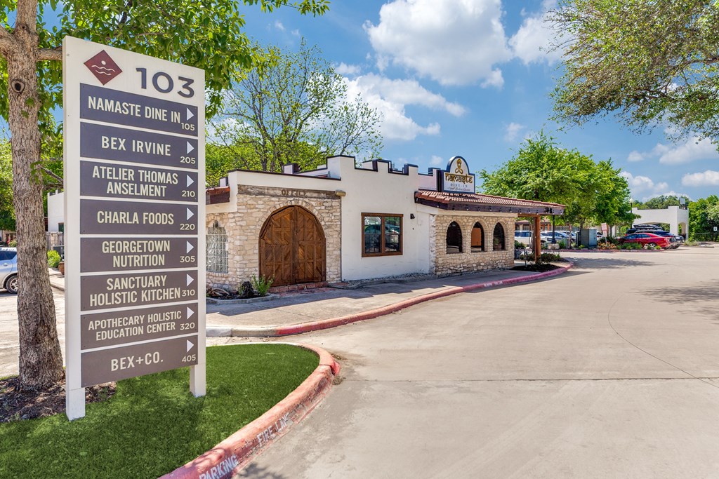a sign in front of a taco restaurant with a parking lot