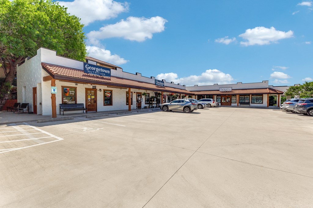 a parking lot in front of a shopping center with cars parked