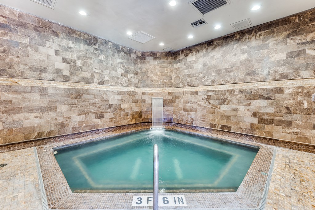 a large pool of water in a spa with stone walls