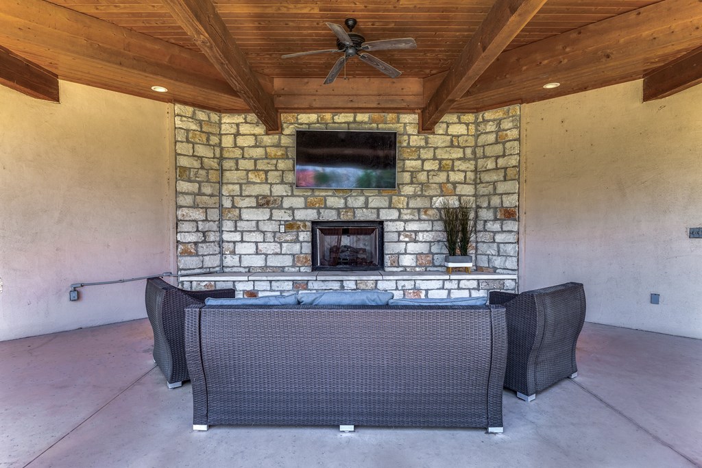 a patio with a fireplace and a table and chairs