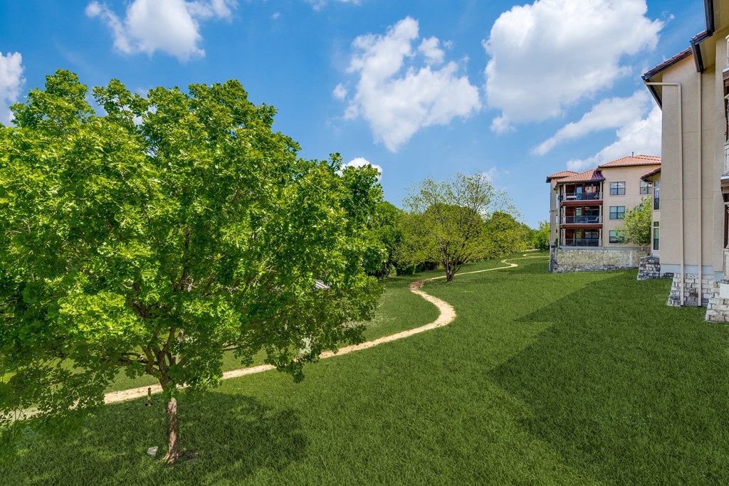 a path through the grass next to a building
