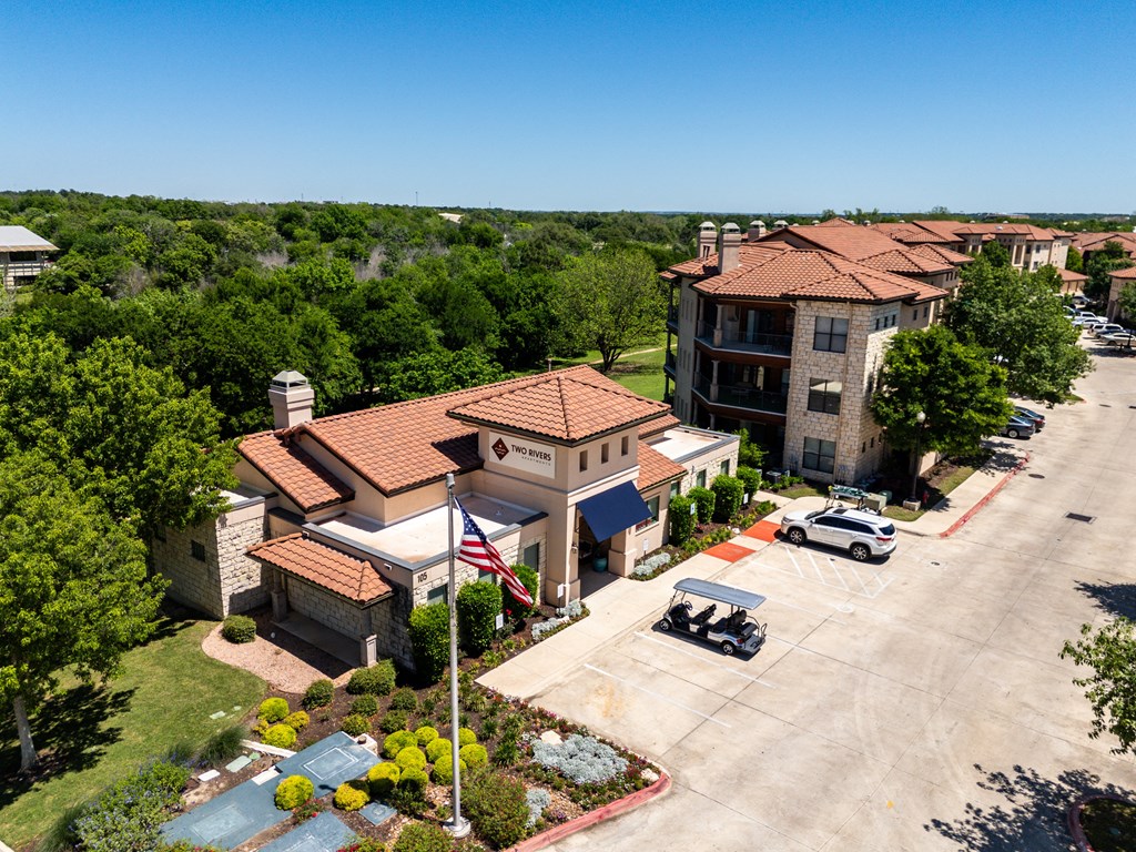 an aerial view of a building with cars parked in front of it