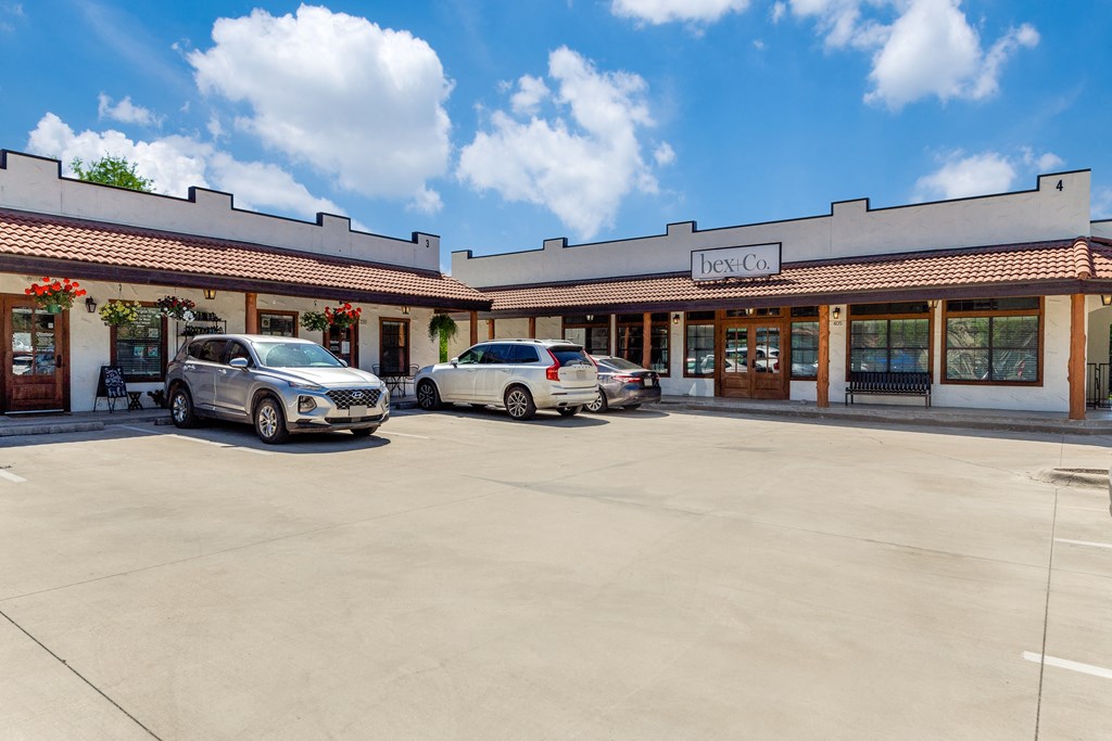 the front of a restaurant with two cars parked in front of it