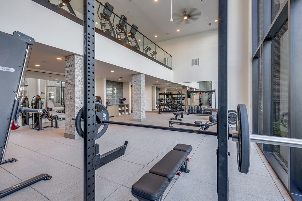 a gym with weights and other equipment and a staircase
