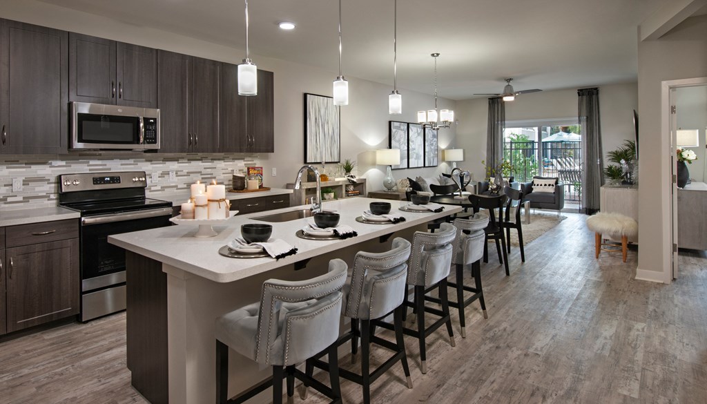 an open kitchen and dining area with a large island with chairs