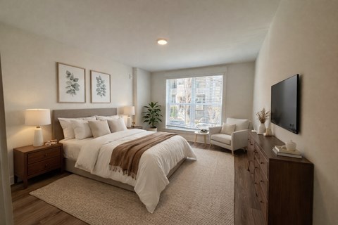 A bedroom with a large bed and a flat screen TV mounted on the wall.