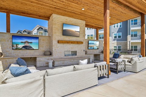 A person is lying on a couch in a living room with a television and a fireplace.