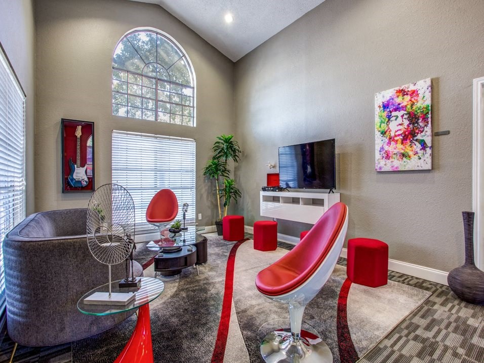 a living room with red chairs and a tv