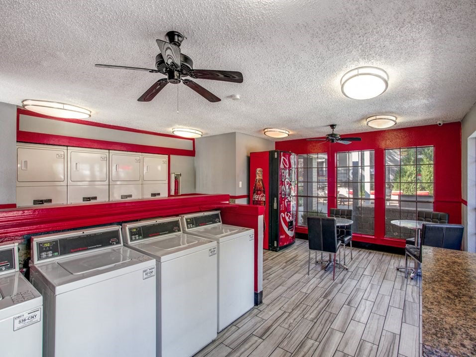 a laundry room with washer and dryers and a table with chairs