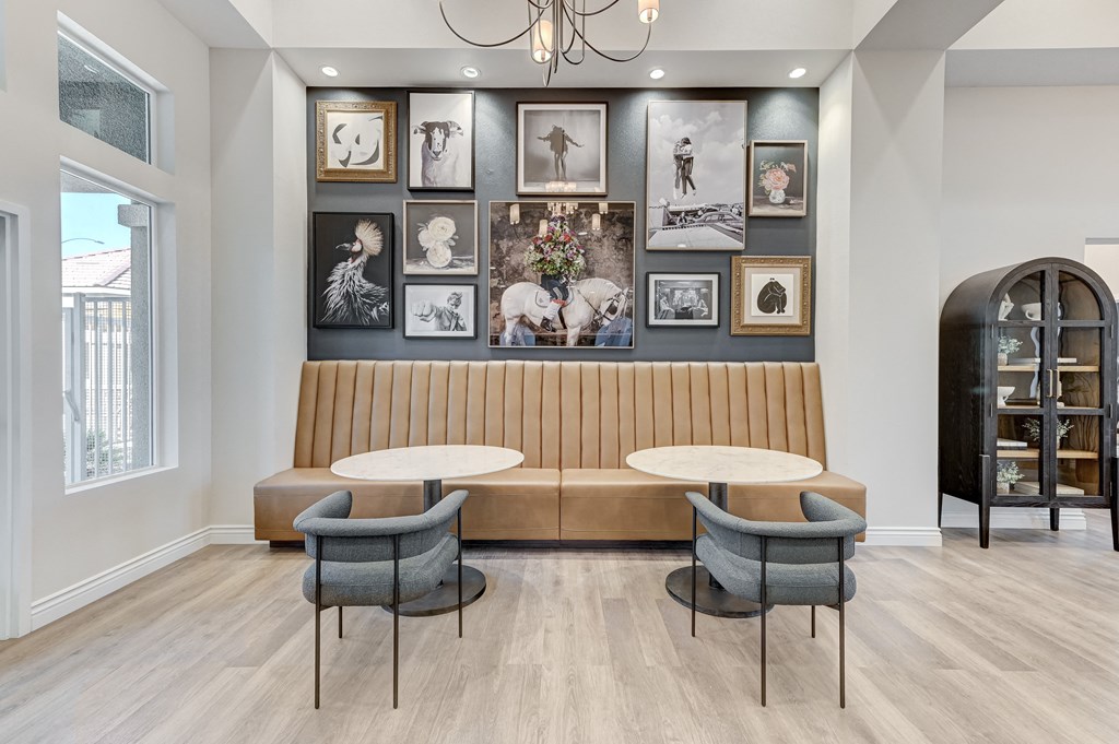 a room with two tables and a couch and pictures on the wall