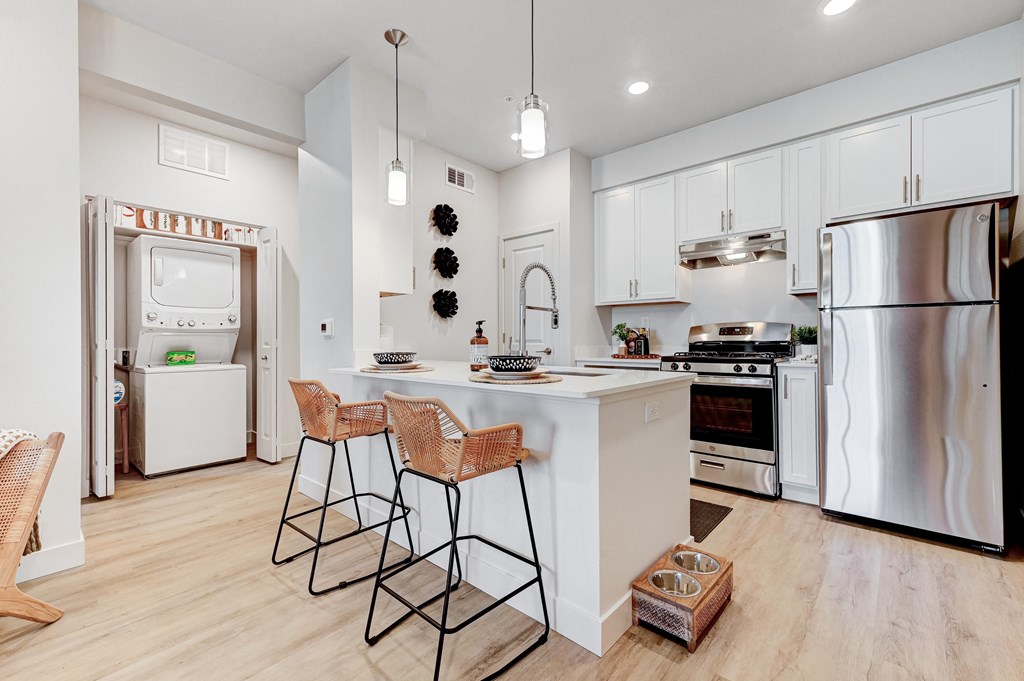 a kitchen with a large island with three bar stools