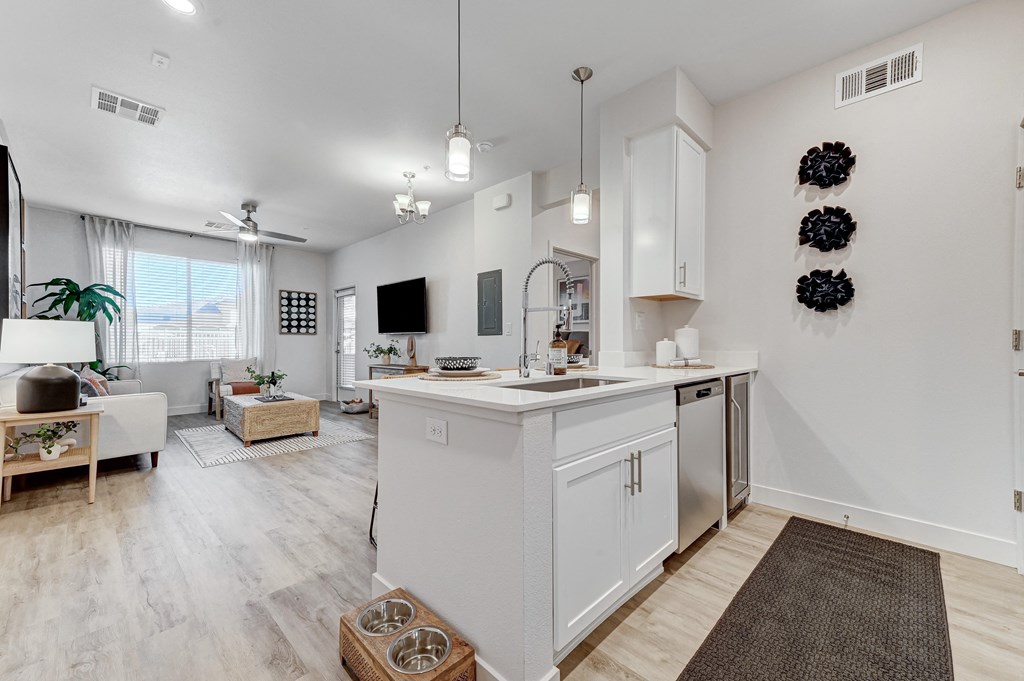 the living room and kitchen of a house with white cabinets and a white kitchen island