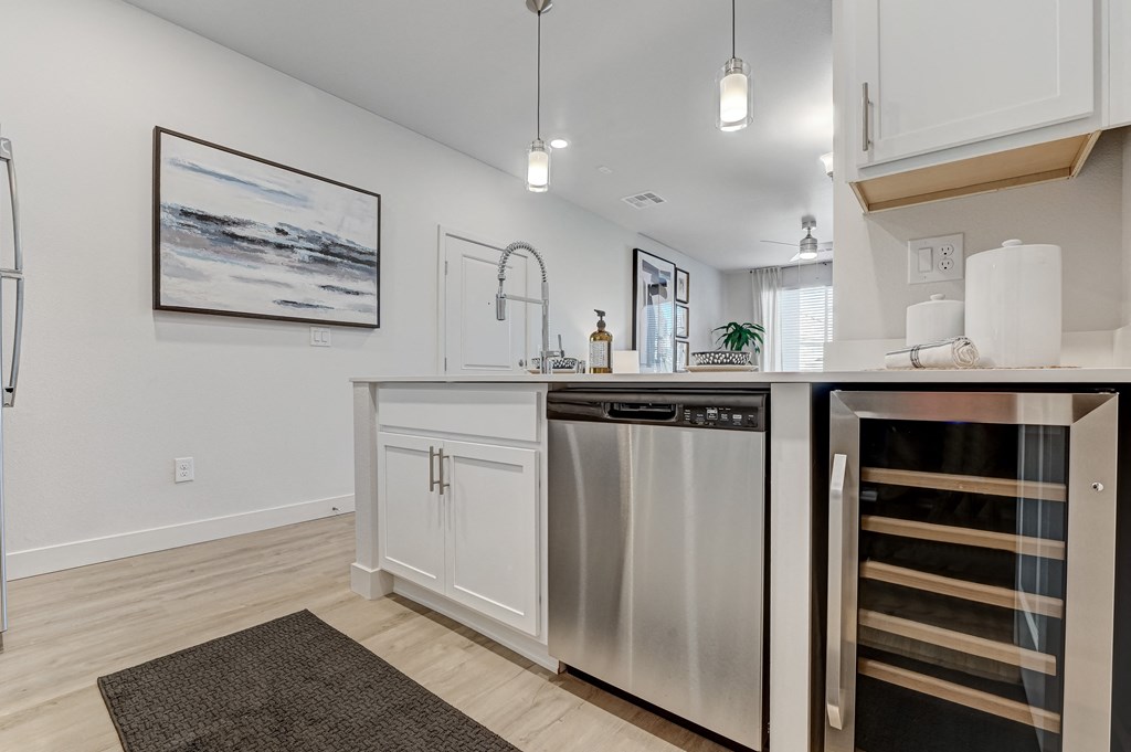 a kitchen with a stainless steel dishwasher and a wine rack