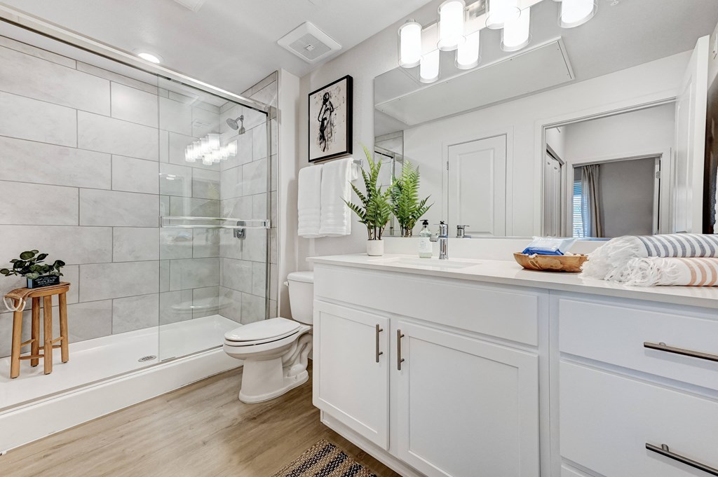 a white bathroom with a shower toilet and sink