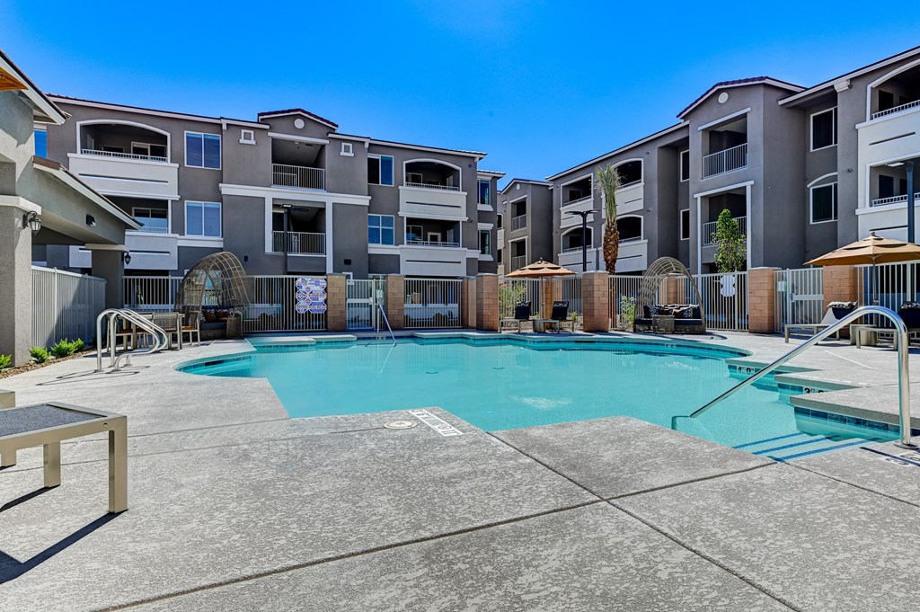 a swimming pool with an apartment building in the background