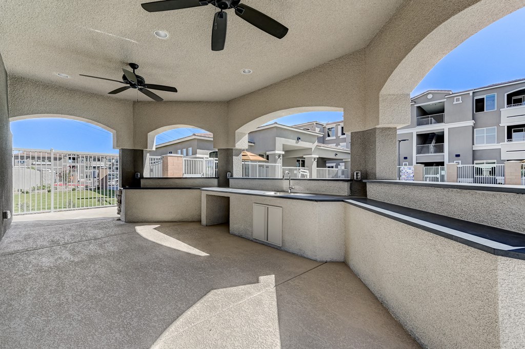 a large balcony with a kitchen and a ceiling fan