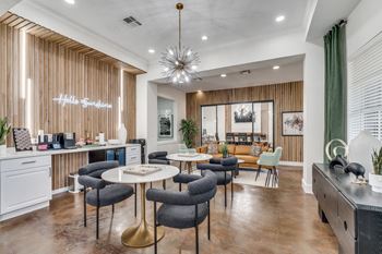a living room with tables and chairs and a kitchen