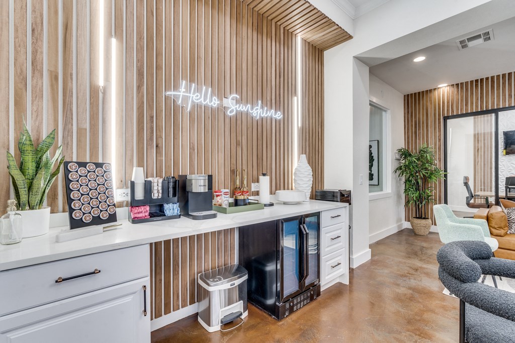 a hotel lobby with a counter with coffee machines and a sign on the wall