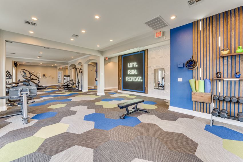 a gym with weights and cardio machines and a chalkboard on the wall - Photo Gallery